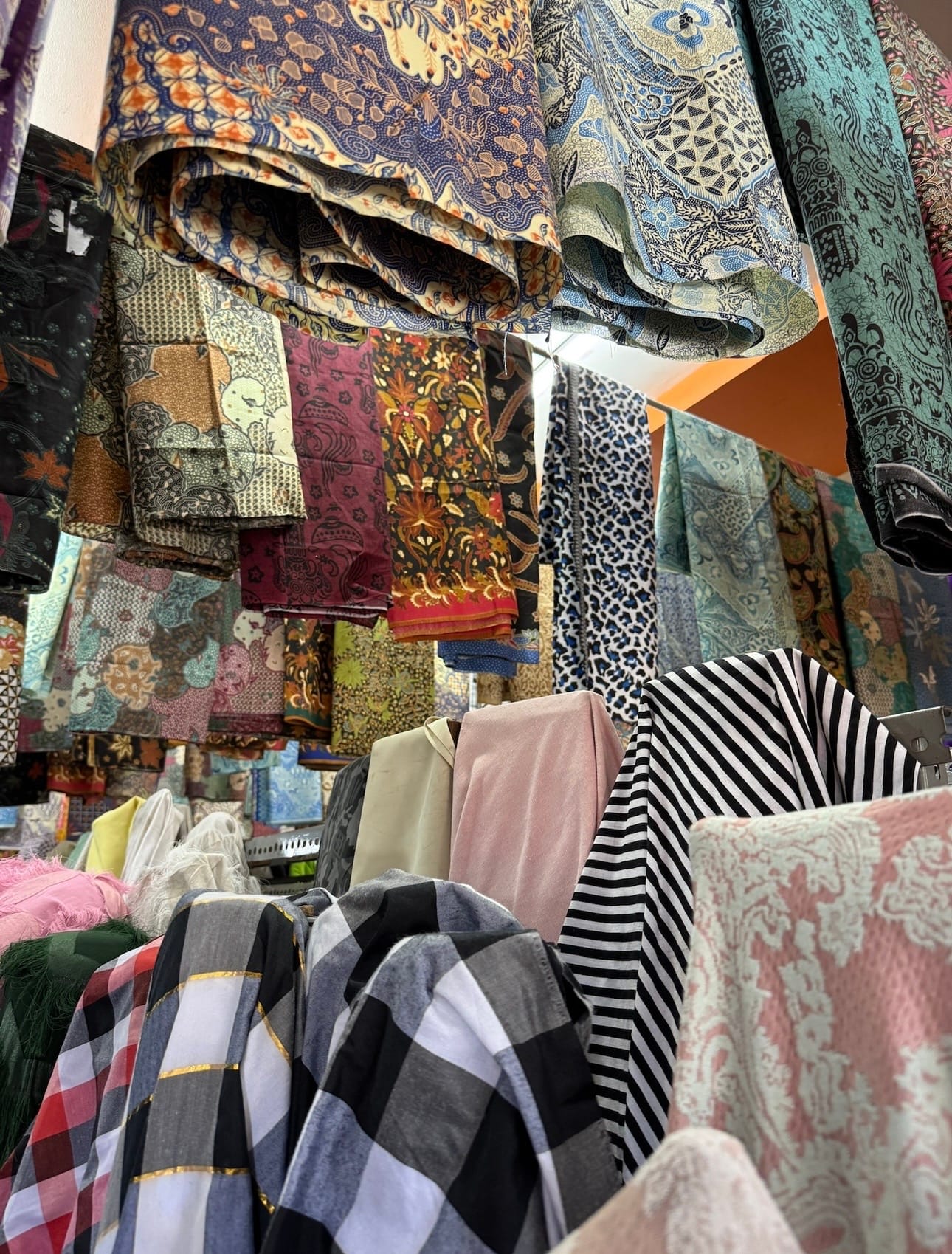 Sove behind-the-scenes fabric sourcing photo with patterned textiles hanging